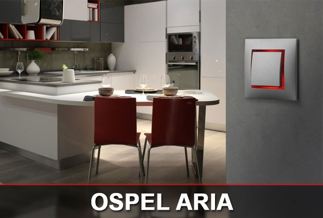 Srebrny łącznik Ospel Aria z czerwonym podświetleniem zamontowany w nowoczesnej kuchni z białą zabudową i czerwonymi krzesłami.