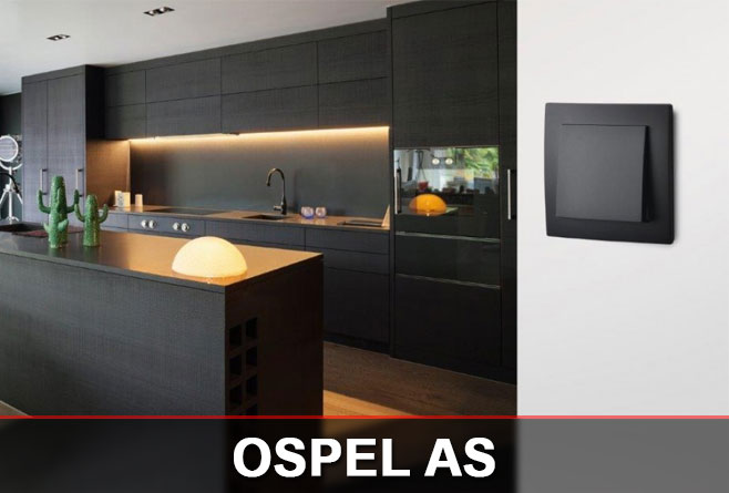 Czarny łącznik Ospel AS na jasnej ścianie w nowoczesnej kuchni z ciemną zabudową i wyspą kuchenną.